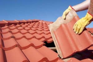 Worker With Yellow Gloves Doing Roof Replacement